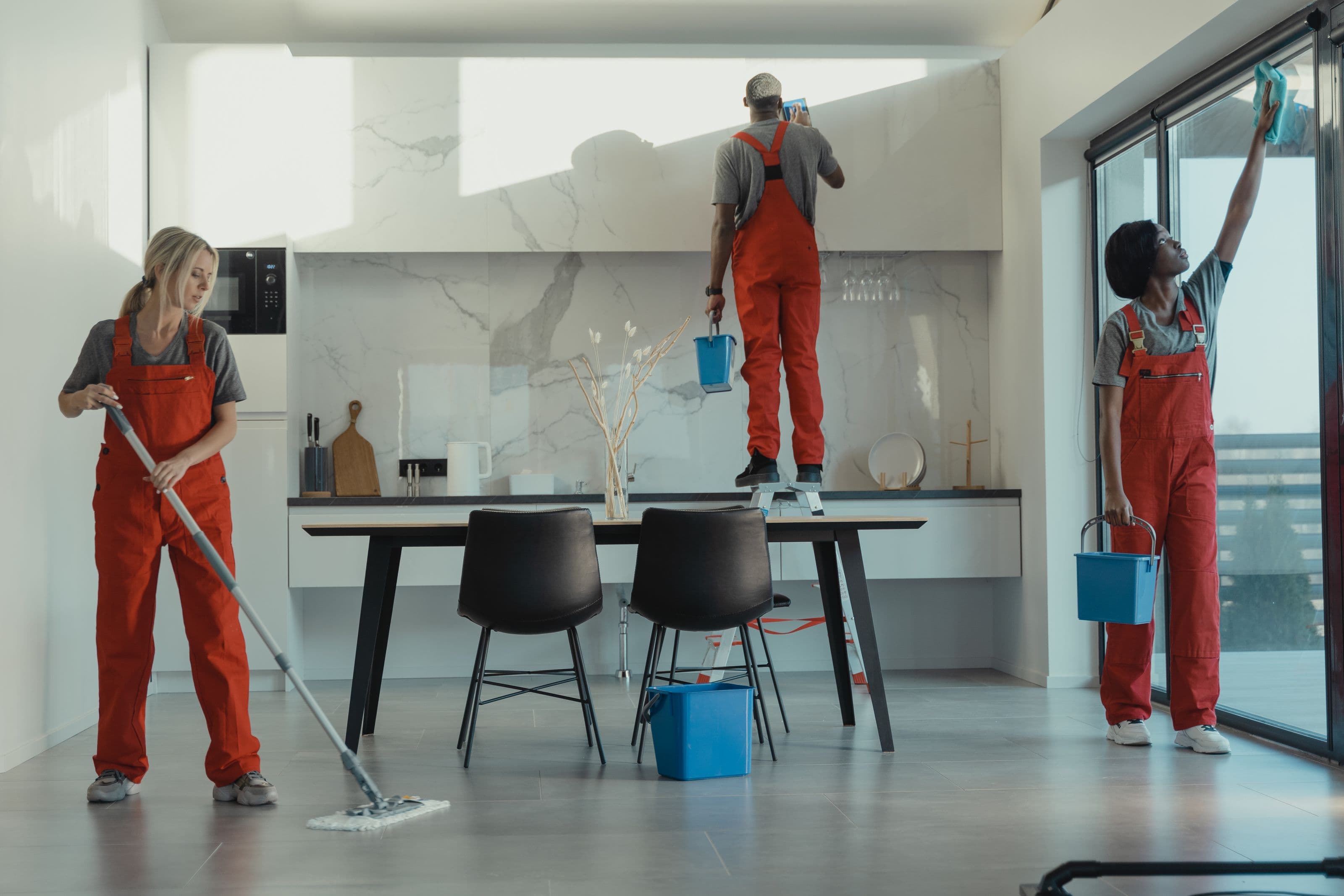 A cleaning team at work in a bright London kitchen.