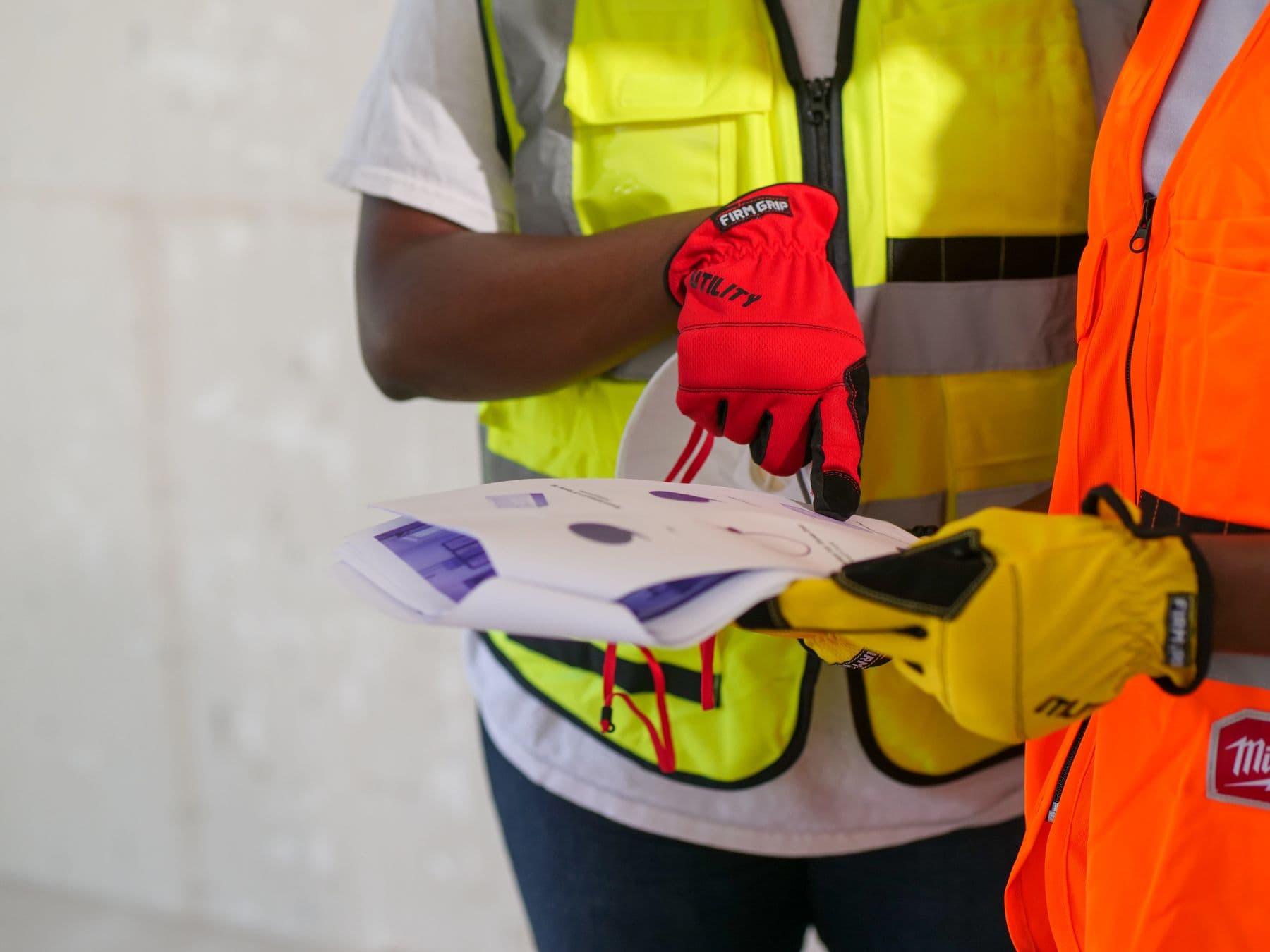 Site staff in high-visibility vests reviewing a job sheet before a shift.